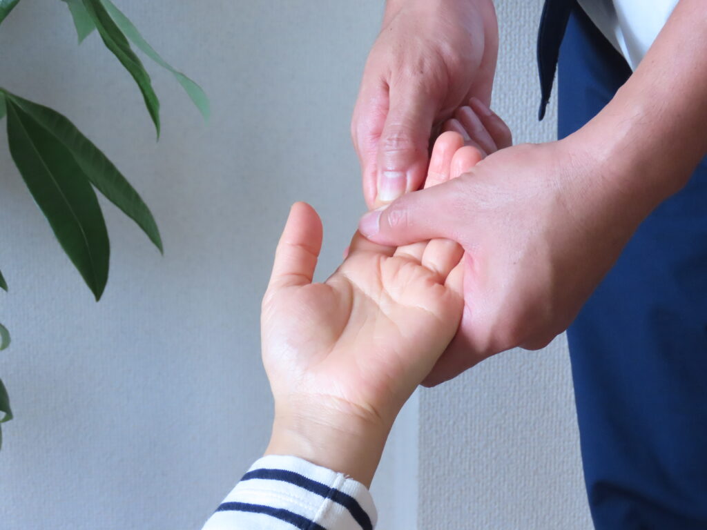 肩こりの施術で手の指を調整している様子